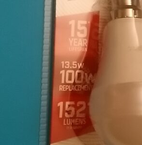 Lightbulb in packaging. "15 year warrantee. 13.5W. 100W replacement. 1527 Lumens."